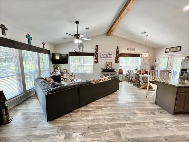 a kitchen with stainless steel appliances granite countertop a stove oven and a view of living room