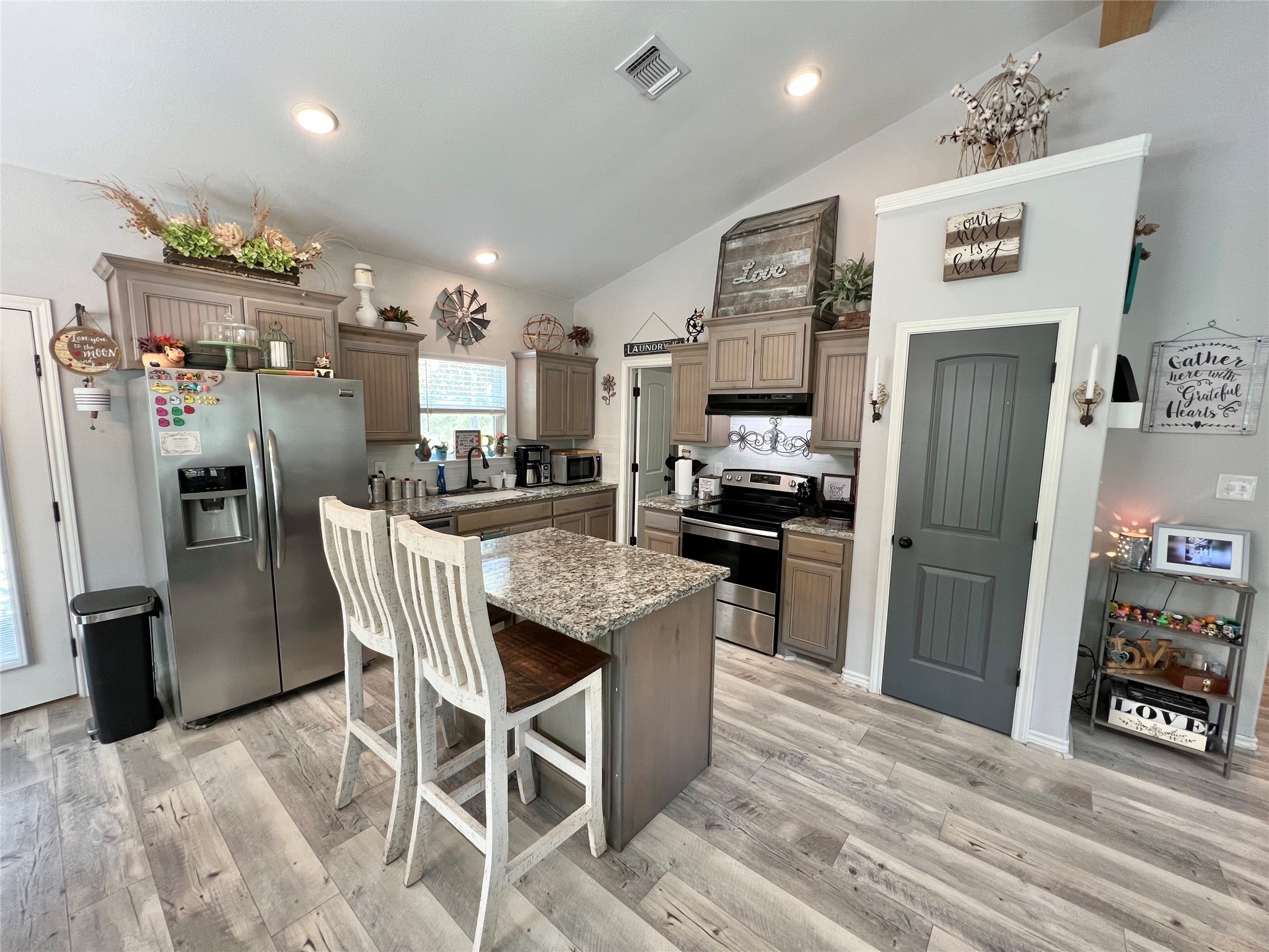22740 Brazos Circle Damon, TX 77430 - Photo 10 of 30 a kitchen with stainless steel appliances kitchen island granite countertop a refrigerator a stove a microwave oven a sink with island and chairs