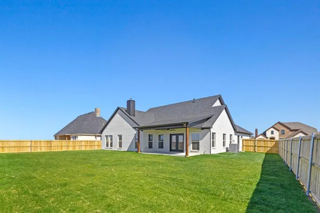 a view of a big house with a big yard and large trees