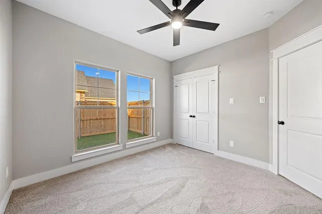 an empty room with chandelier fan