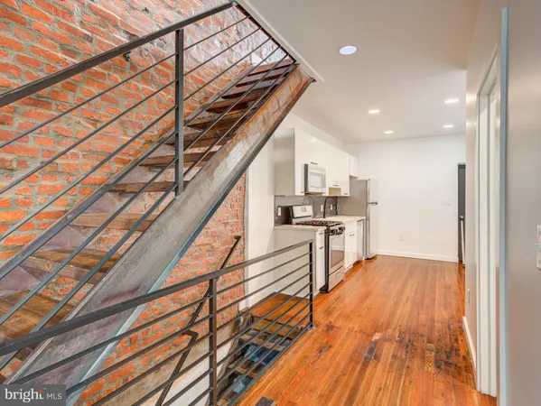 a view of entryway and kitchen with wooden floor