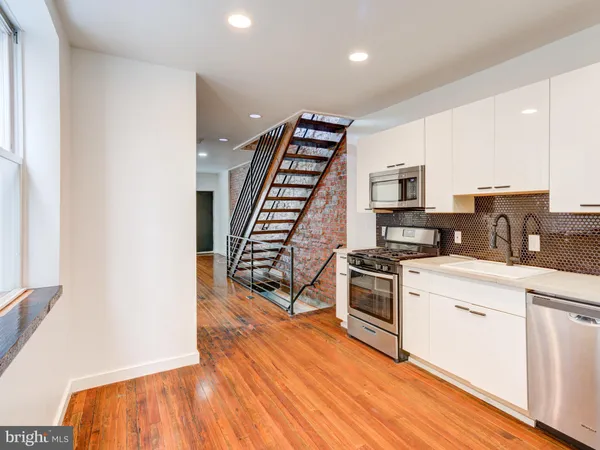 a kitchen with wooden floors and appliances
