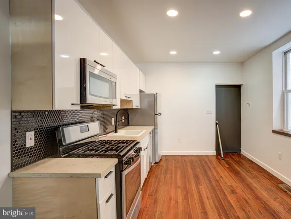 a kitchen with a stove and white cabinets