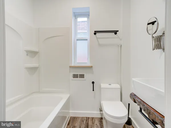 a white toilet sitting next to a bath tub