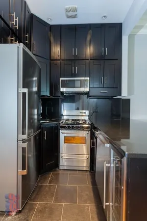 a kitchen with stainless steel appliances granite countertop a refrigerator and a sink