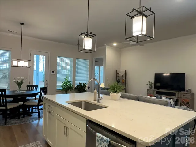 a kitchen with stainless steel appliances a dining table chairs and a chandelier