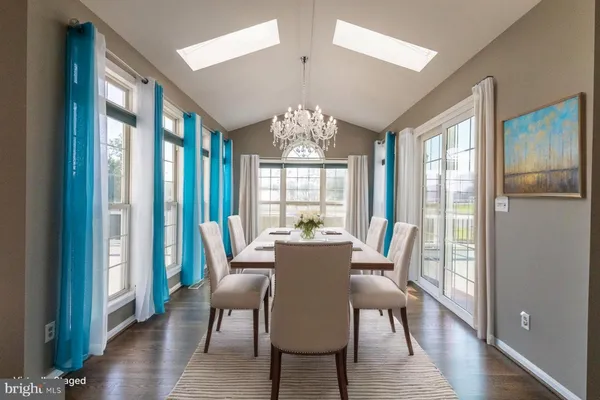 an empty room with chandelier and windows