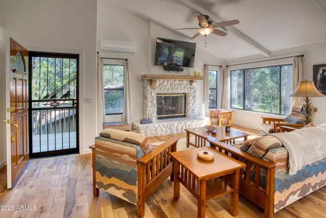 a living room with furniture a flat screen tv and a fireplace