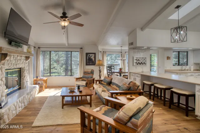 a living room with furniture a flat screen tv and kitchen view