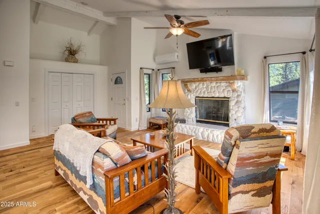 a living room with furniture a flat screen tv and a fireplace