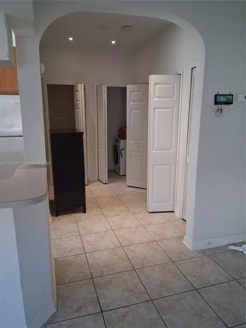 a view of hallway with a furniture and a refrigerator