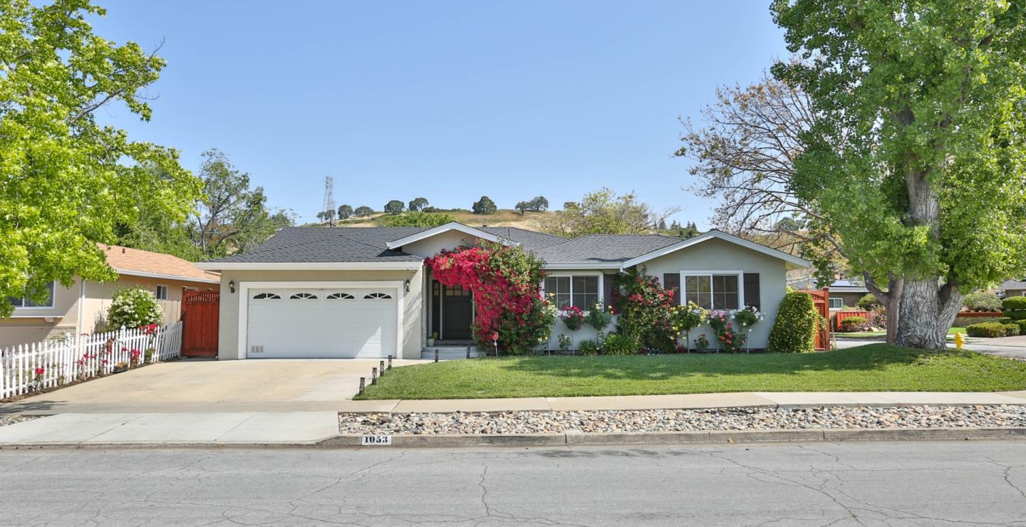 a front view of a house with a yard and potted plants