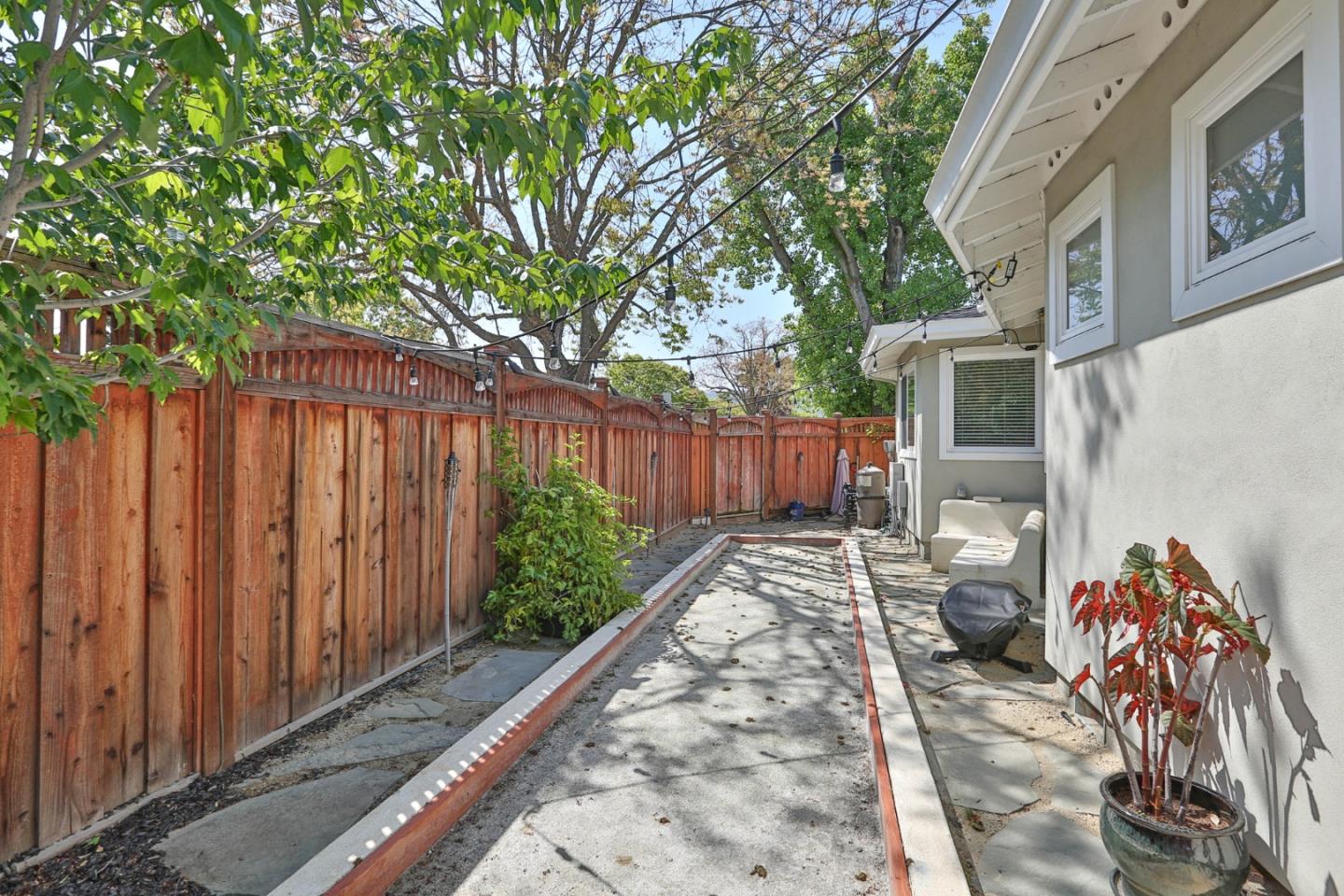 1053 Wallace Drive San Jose, CA 95120 - Photo 32 of 36 a view of a backyard with table and chairs and wooden fence