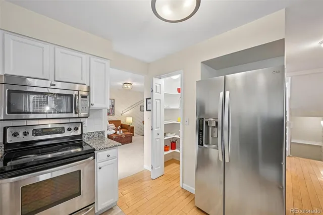 a kitchen with stainless steel appliances granite countertop a refrigerator and a stove top oven