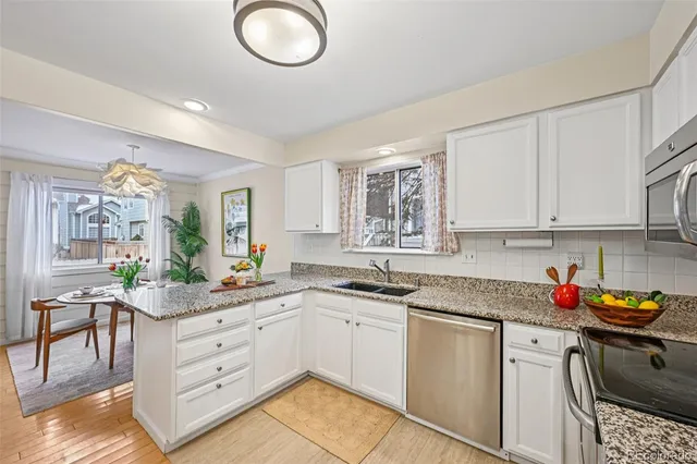 a kitchen with granite countertop a sink stainless steel appliances and cabinets