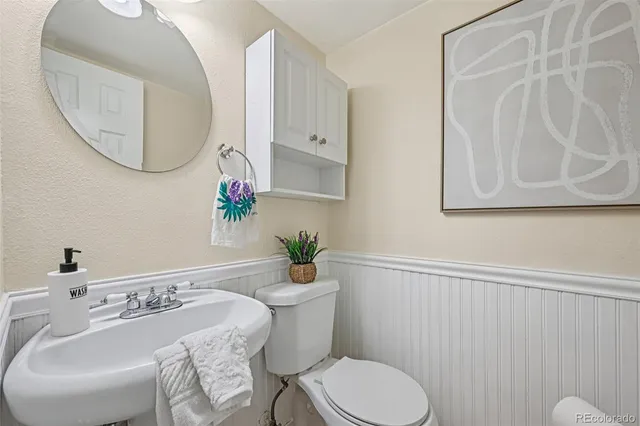 a bathroom with a sink mirror and toilet