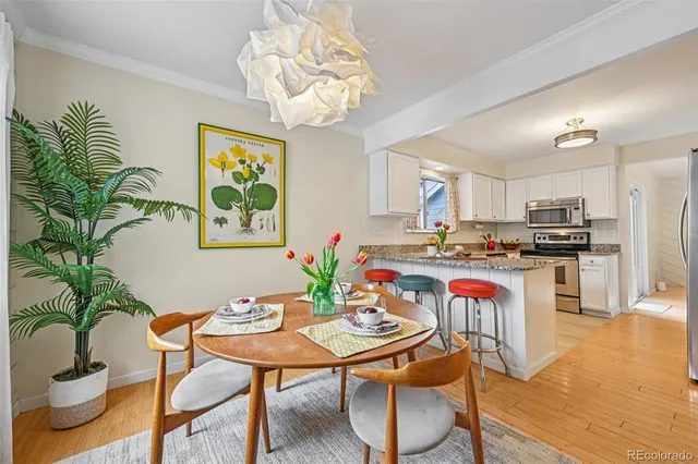 a view of a dining room with furniture a chandelier and wooden floor
