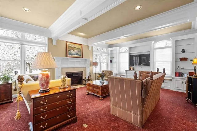a living room with furniture a fireplace and a large window