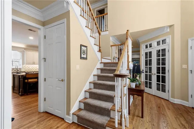 a view of a hallway with wooden floor and staircase