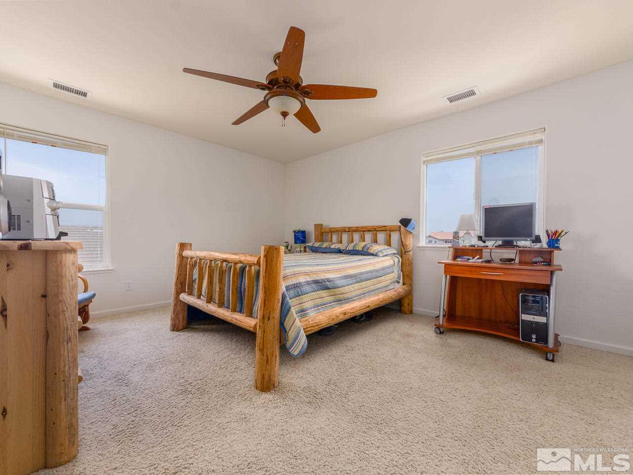 545 Luciana Drive Reno, NV 89521 - Photo 21 of 24 a bedroom with a bed and a chandelier