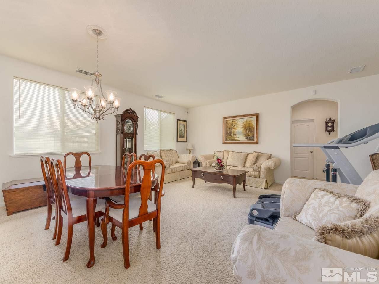 545 Luciana Drive Reno, NV 89521 - Photo 7 of 24 a living room with furniture a chandelier and a dining table