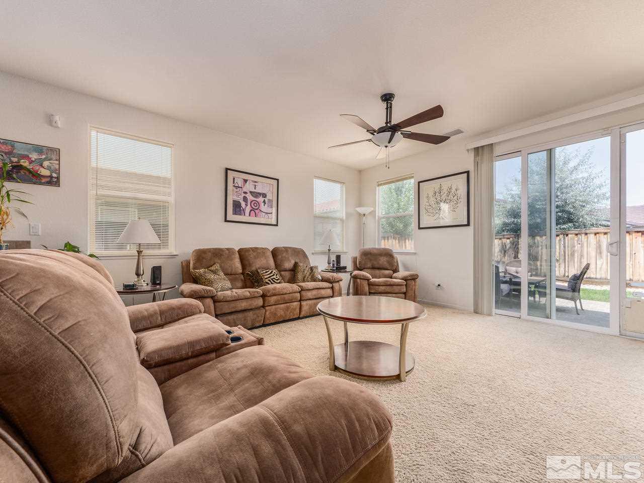 545 Luciana Drive Reno, NV 89521 - Photo 9 of 24 a living room with furniture a large window and a chandelier