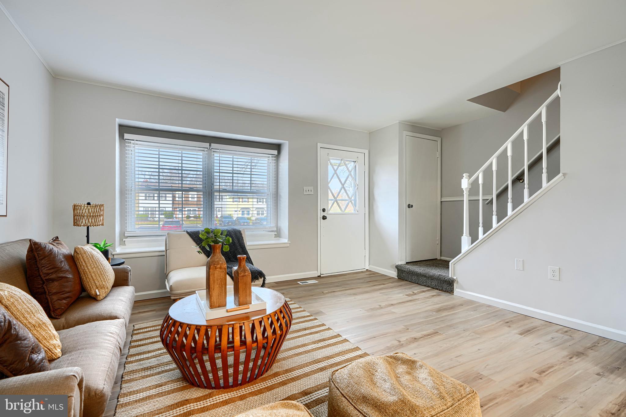 a living room with furniture a table and a large window