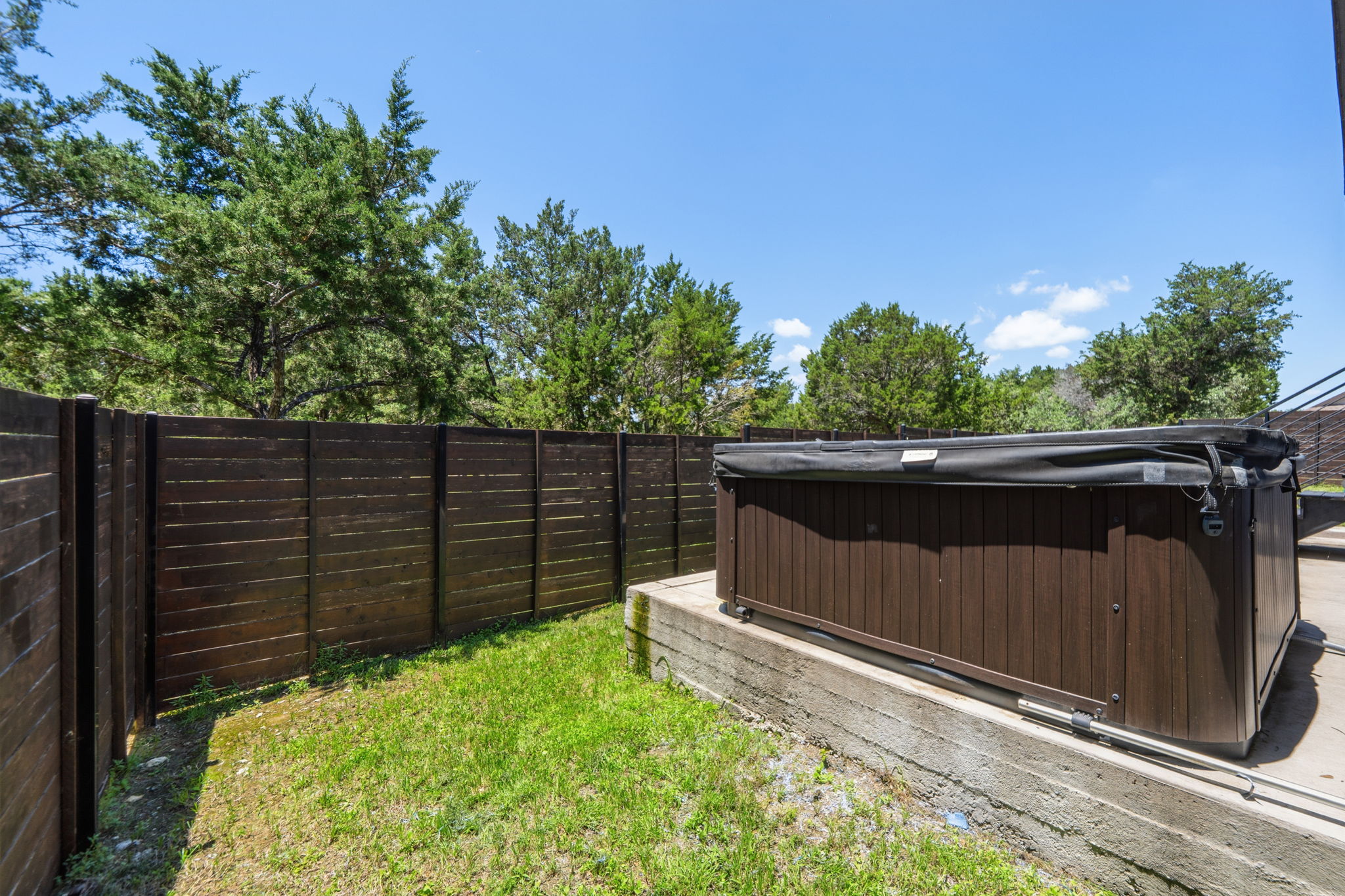 18605 Masters Cove Point Venture, TX 78645 - Photo 32 of 40 Outdoor spa on a concrete pad, surrounded by a dark wood-paneled privacy fence