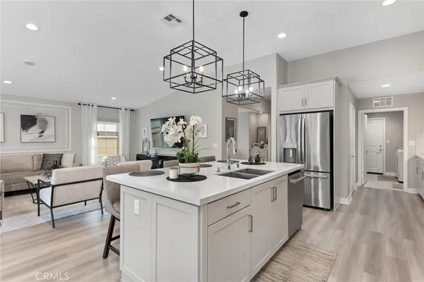 a view of a center island dining table wooden floor and windows