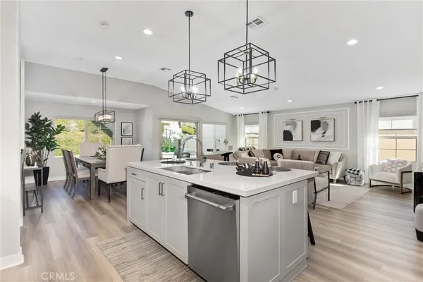 a view of a dining room and livingroom with furniture wooden floor a chandelier