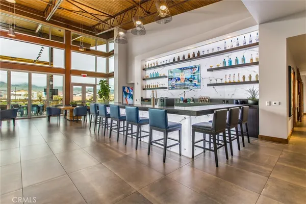 a dining hall with stainless steel appliances granite countertop a table and chairs with wooden floor