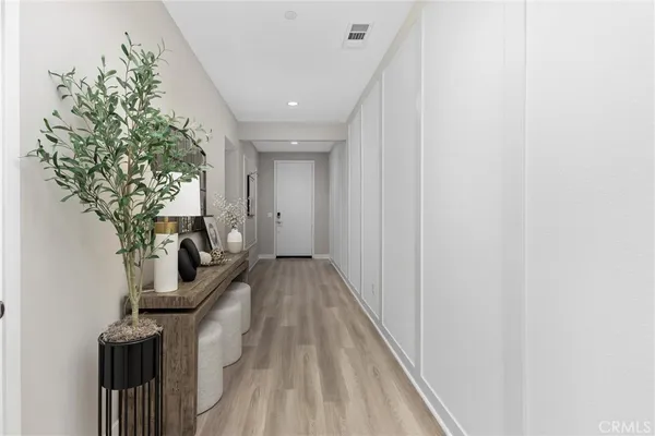 a view of a hallway with wooden floor and staircase