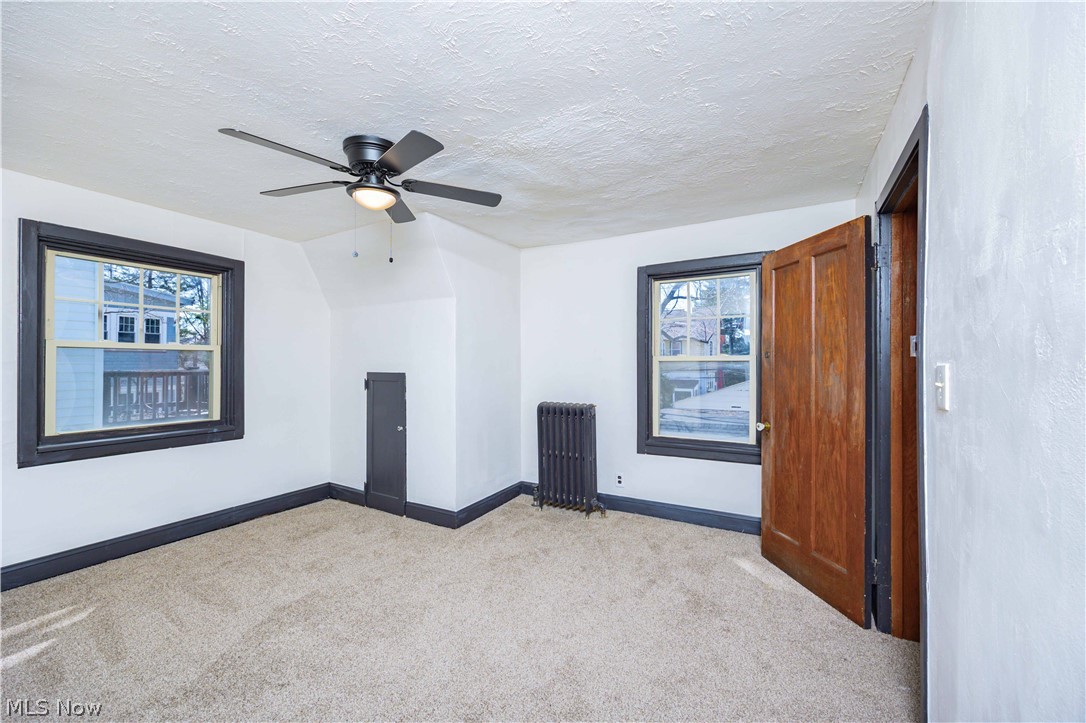 3254 Redwood Road Cleveland Heights, OH 44118 - Photo 32 of 49 Spare room featuring ceiling fan, radiator, a textured ceiling, and plenty of natural light