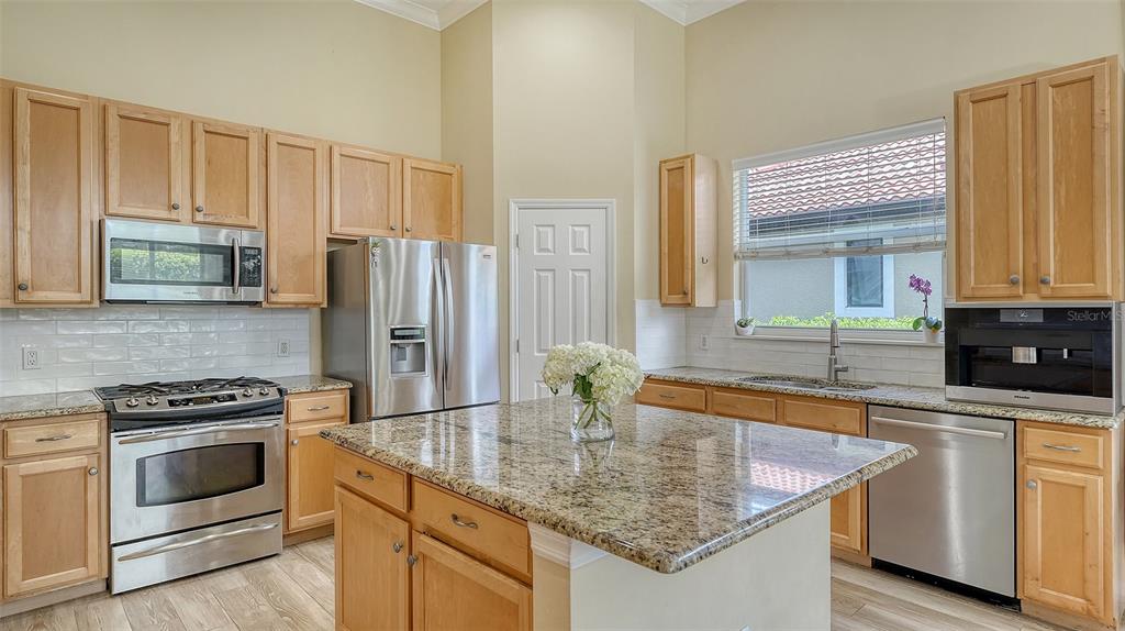 7717 US Open Loop Lakewood Ranch, FL 34202 - Photo 11 of 95 a kitchen with stainless steel appliances granite countertop a sink stove and refrigerator