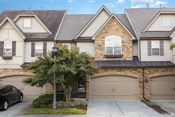 a view of a white house with large windows and a small yard