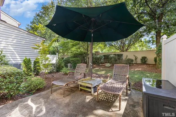 a view of a patio with table and chairs under an umbrella