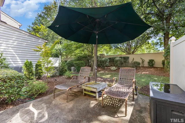 a view of a patio with table and chairs under an umbrella