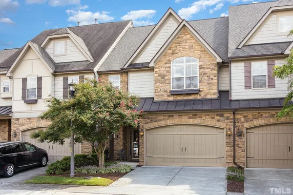 a view of a white house with large windows and a potted plant