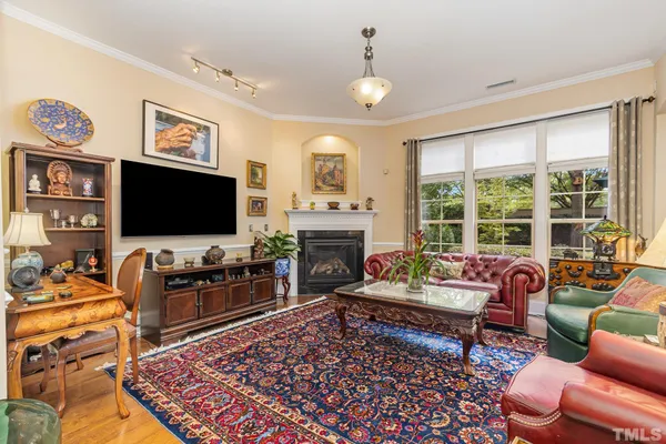a living room with furniture floor to ceiling window and a flat screen tv