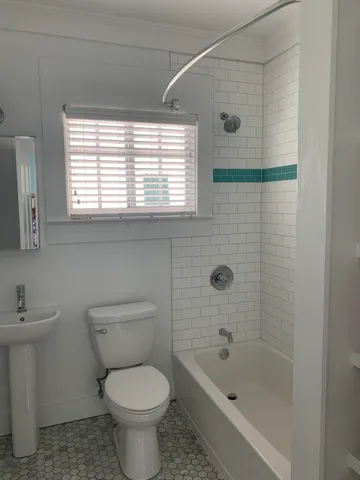 a view of an empty room with window and a ceiling fan