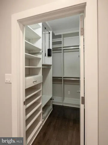 a view of walk in closet with empty racks
