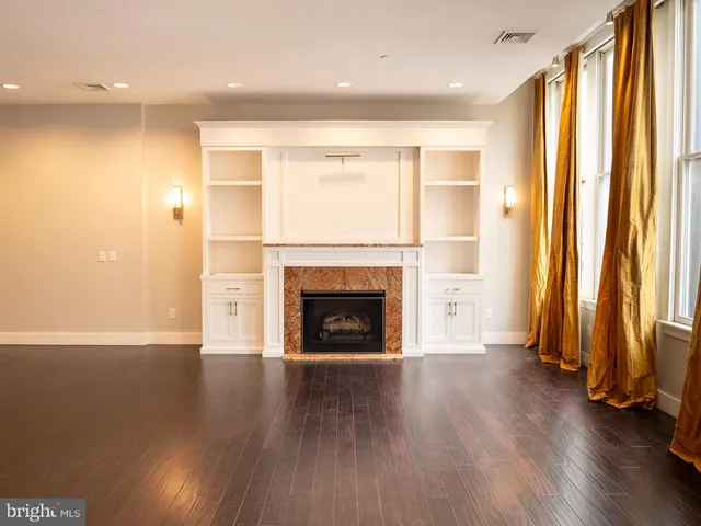 an empty room with wooden floor and a fireplace