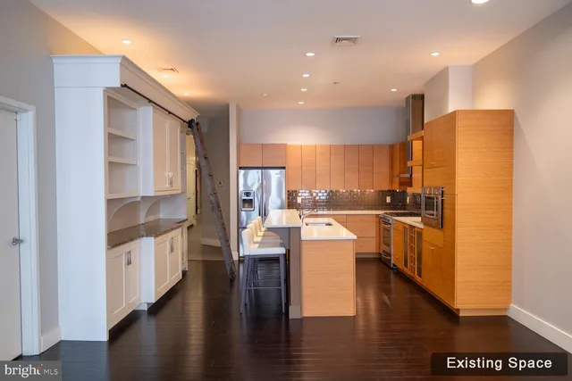 a kitchen with stainless steel appliances a refrigerator a stove top oven and a refrigerator