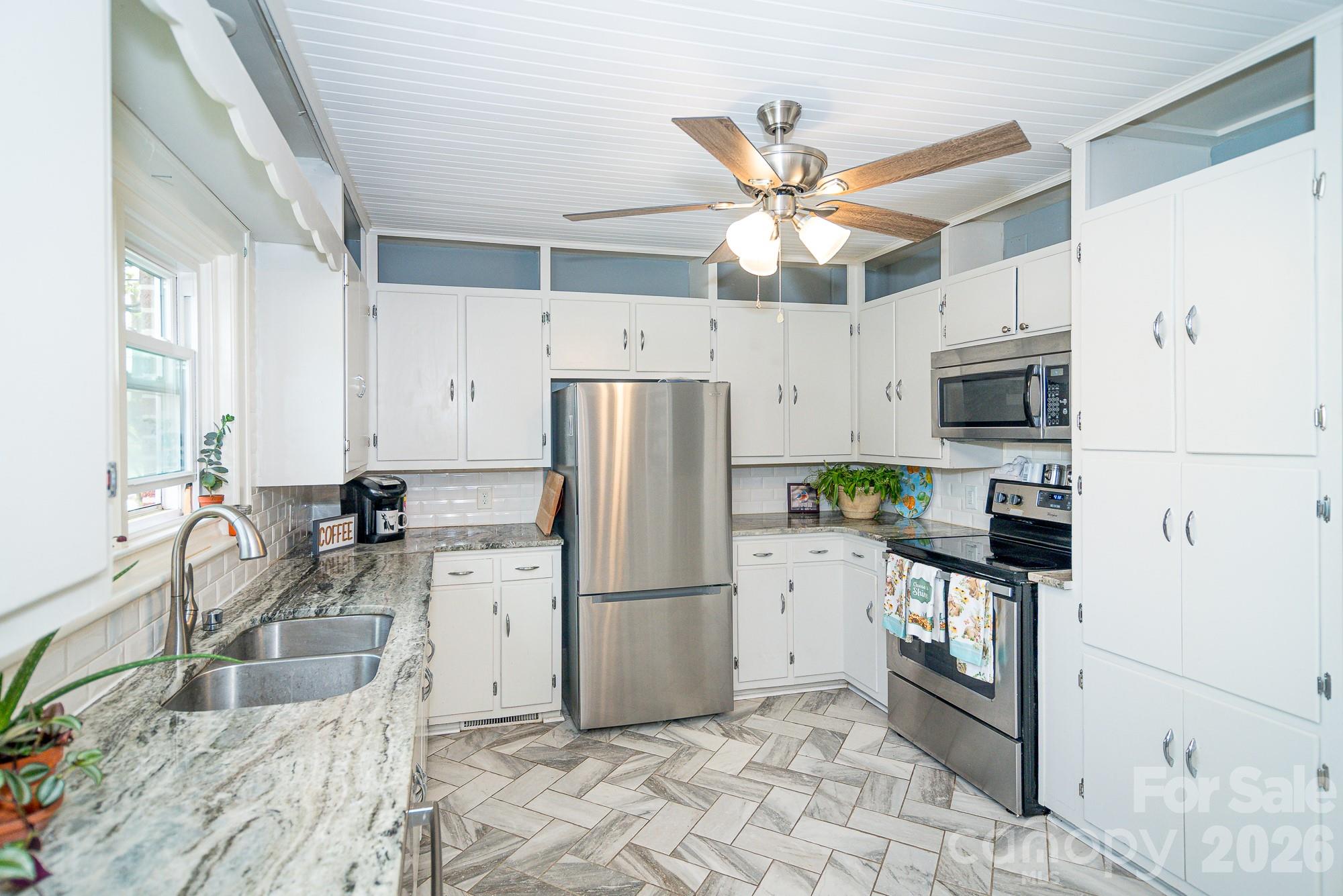 610 East Main Street Cherryville, NC 28021 - Photo 26 of 48 a kitchen with stainless steel appliances granite countertop a refrigerator a stove a sink a oven with a dining table and chairs