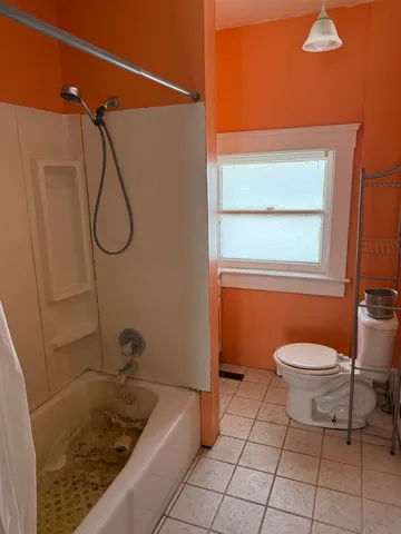 a bathroom with a granite countertop sink a toilet and shower