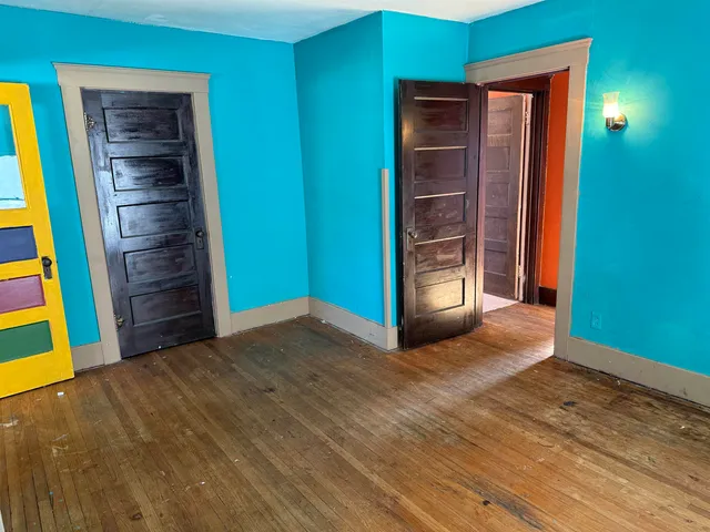 a view of an empty room with closet and a fireplace