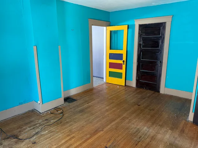 a view of empty room with wooden floor and closet