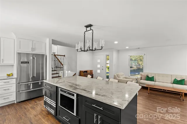 a kitchen with stainless steel appliances granite countertop a sink refrigerator and microwave