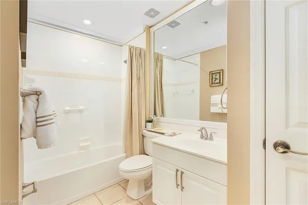 a bathroom with a bathtub shower sink mirror and toilet