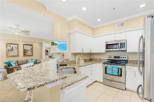 a kitchen with stainless steel appliances granite countertop a sink and cabinets